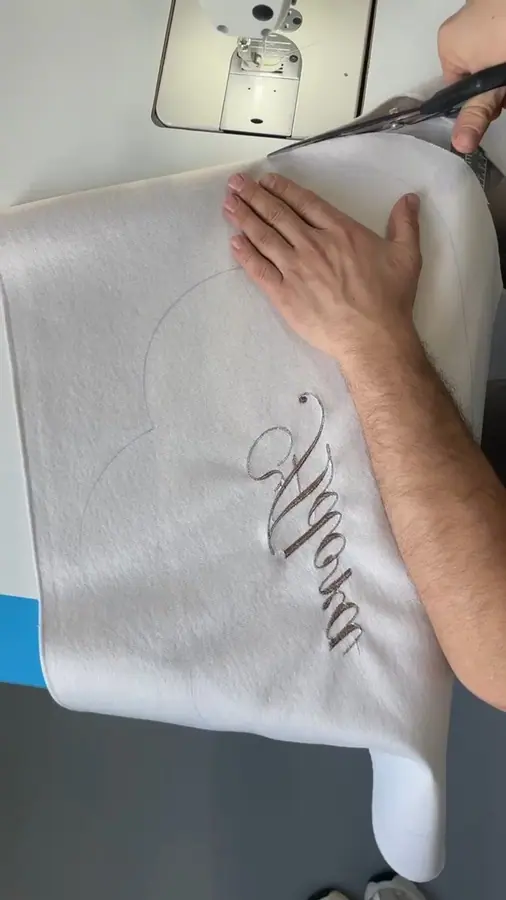 Cutting an embroidered cloud pillow in the KAM workshop